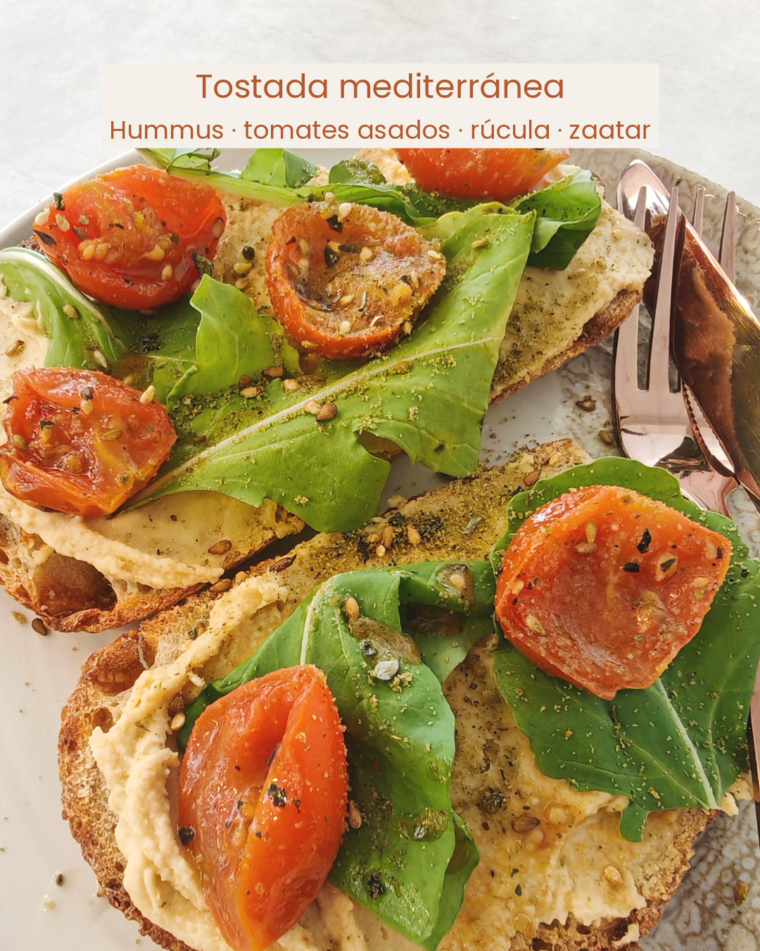 Tostada mediterránea — hummus, tomates asados, rúcula